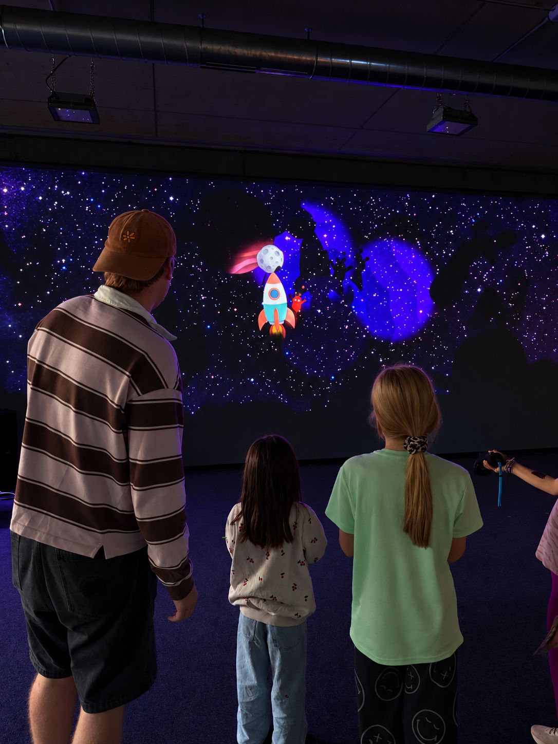 Adults and children viewing the Maus installation at EUREF