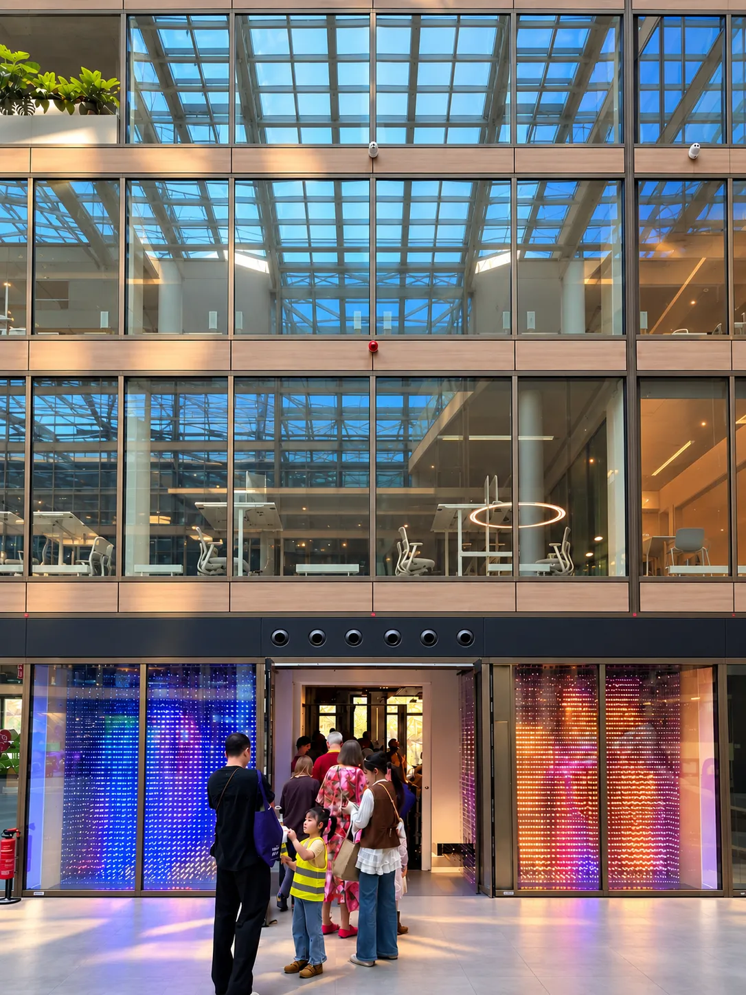 Visitors at the illuminated LUPIXX entrance on the EUREF Campus